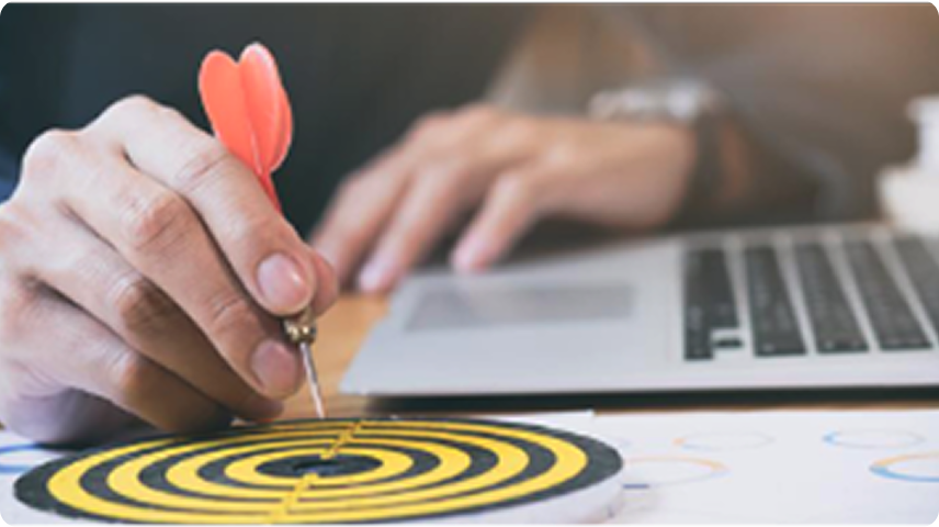 Hand placing a dart in the bullseye, representing goals-based planning